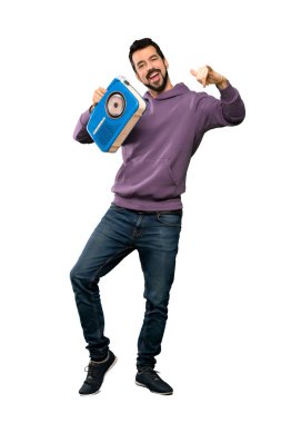 Yakışıklı bir radyo izole beyaz arka plan üzerinde tutarak kazak ile tam uzunlukta atış