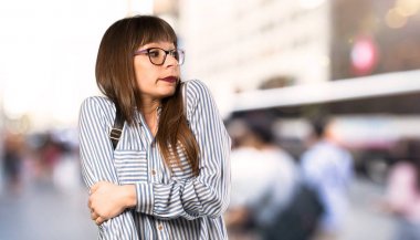 Açık havada omuzları kaldırarak gözlüklü kadın şüphe jest yapma