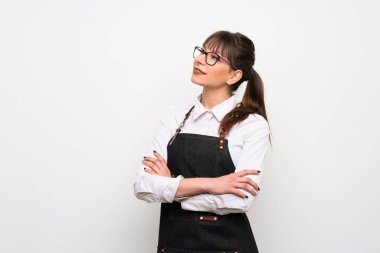 Önlüklü genç kadın mutlu ve gülümsüyor.