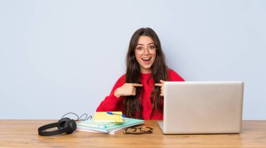 Sürpriz yüz ifadesi ile bir tabloda okuyan genç öğrenci kız