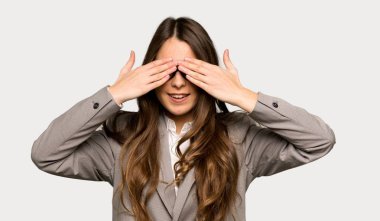 İş kadını gözleri elinde saklıyor. İzole gri arka plan üzerinde ileride ne olduğunu görmek için sürpriz