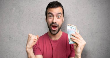 Adam dokulu duvar üzerinde kazanan pozisyonda bir zafer kutluyor para alarak çok