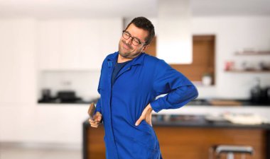 Evde çaba gösterirken arka ağrıdan muzdarip ressam adam