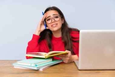 Bir masada okuyan sinirli genç öğrenci kız