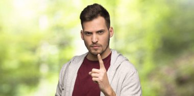 Sweatshirt ile adam sinirli ve bir parkta ön işaret