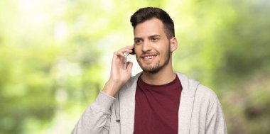 Bir parkta cep telefonu ile bir konuşma tutarak Sweatshirt ile adam