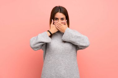 Genç kadın üzerinde pembe duvar eller ile ağız kapsayan