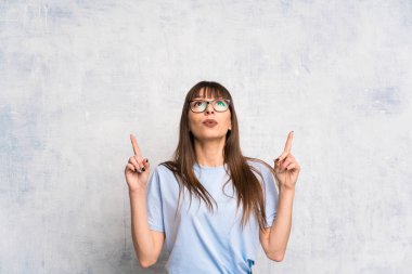 Grunge arka planda genç bir kadın işaret parmağıyla işaret etmek harika bir fikir.
