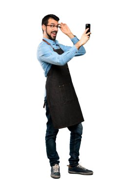 Tam boy çekim apron ile izole beyaz arka plan üzerinde bir selfie yapma