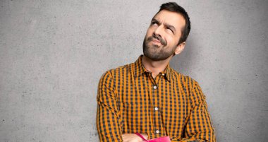 Dokuma duvar üzerinde ciddi yüz ile seyir çanta ile adam