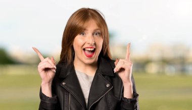 Genç Redhead kadın Dizin parmak açık havada büyük bir fikir işaret