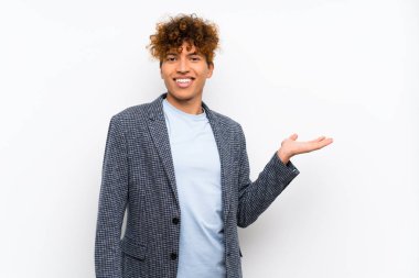 Bir reklam eklemek için avuç üzerinde copyspace hayali tutan izole beyaz duvar üzerinde Moda afro-amerikan adam