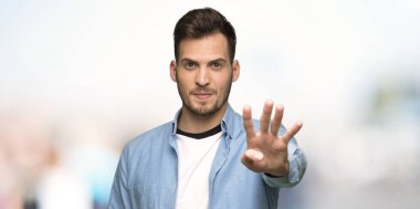 Yakışıklı adam mutlu ve sayım dört açık havada ince ve sert parmaklar ile