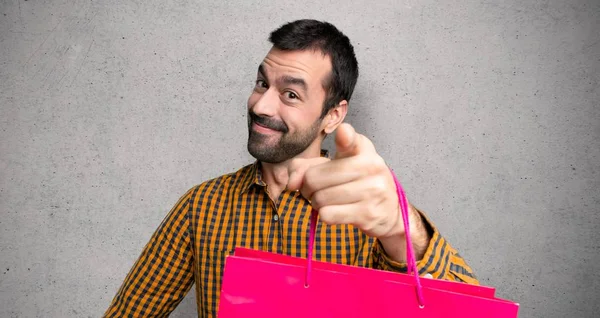 Hombre Con Bolsas Compras Señala Con Dedo Con Una Expresión —  Fotos de Stock