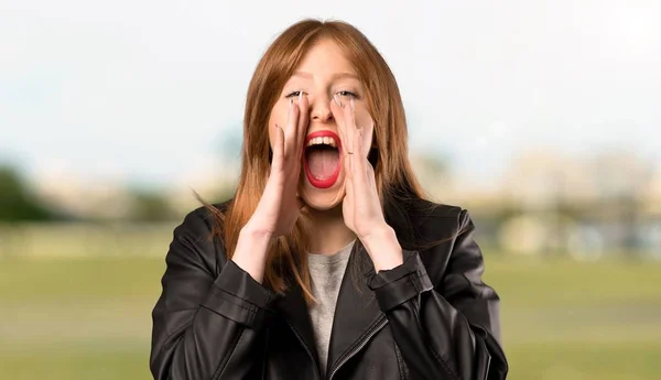 若い赤毛の女性が叫んで 屋外で何かを発表 — ストック写真