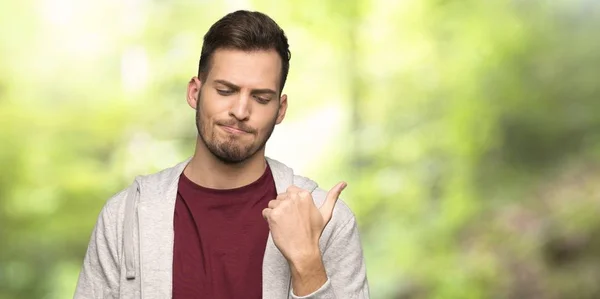 Man Met Sweatshirt Ongelukkig Wijzend Naar Zijkant Een Park — Stockfoto