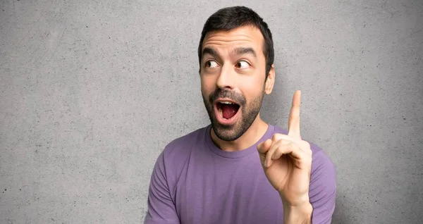 Yakışıklı adam bir fikir dokulu duvar üzerinde parmak işaret düşünme