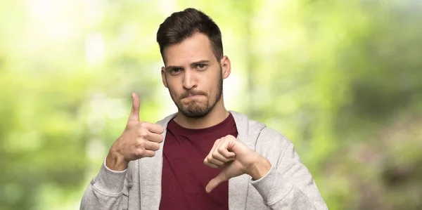 Man Sweatshirt Making Good Bad Sign Undecided Yes Park — Stock Photo, Image