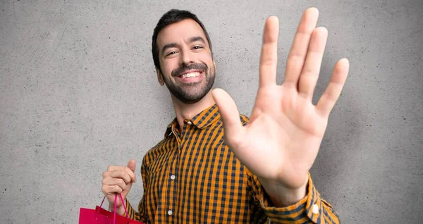 Hombre Con Bolsas Compras Saludando Con Mano Con Expresión Feliz —  Fotos de Stock