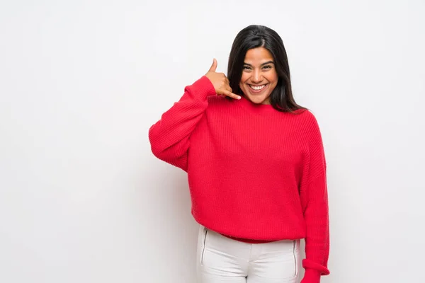 携帯電話のジェスチャーを作る赤いセーターを着た若いコロンビアの女の子 サインを呼んでくれ — ストック写真