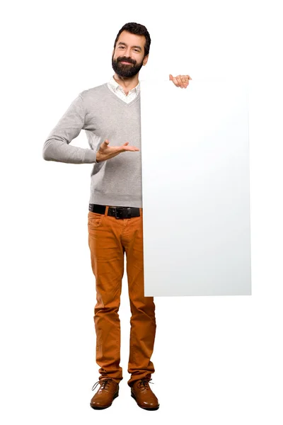 Homem bonito feliz com barba segurando um cartaz vazio — Fotografia de Stock