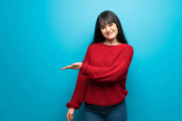 Mujer Con Suéter Rojo Sobre Pared Azul Presentando Una Idea — Foto de Stock