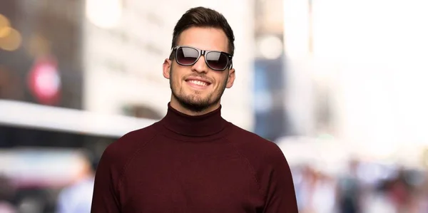 Man with turtleneck sweater with glasses and happy in the city