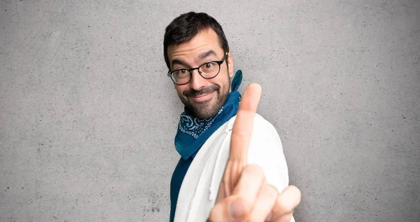 Hombre Guapo Con Gafas Mostrando Levantando Dedo Sobre Pared Texturizada — Foto de Stock