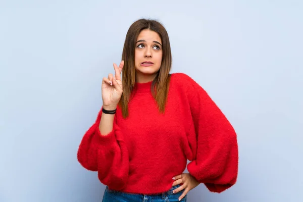 Jovem Mulher Sobre Parede Azul Isolada Com Dedos Cruzando Desejando — Fotografia de Stock