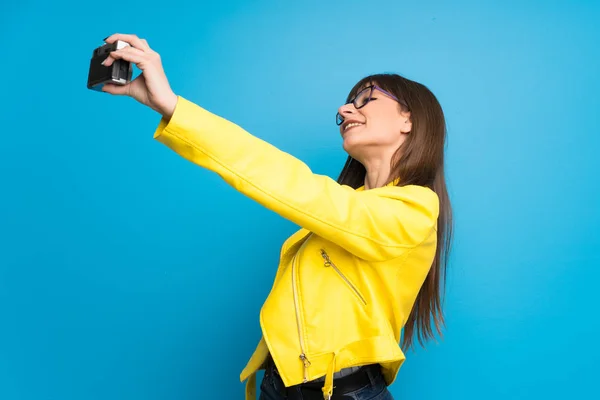 Mujer Joven Con Chaqueta Amarilla Sobre Fondo Azul Sosteniendo Una —  Fotos de Stock