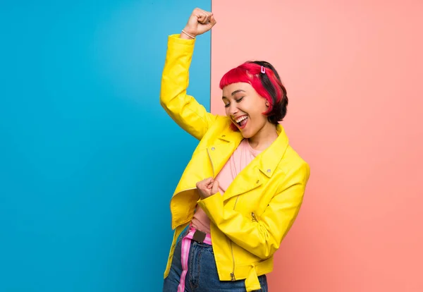 Young woman with yellow jacket celebrating a victory