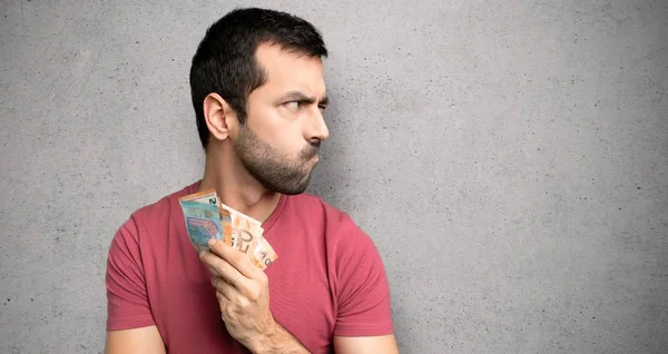 Hombre Tomando Montón Dinero Sintiéndose Molesto Sobre Pared Texturizada — Foto de Stock