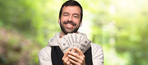 Спортивный человек берет много денег в парке
