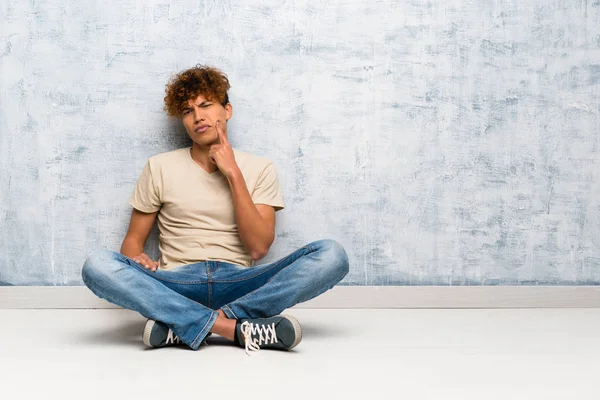 Junger Afrikanisch Amerikanischer Mann Sitzt Auf Dem Boden Und Blickt — Stockfoto