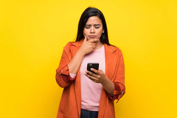 Junge Kolumbianische Mädchen Über Gelbe Wand Mit Einem Handy Und — Stockfoto