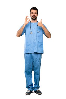Tam uzunluklu çekim cerrah doktor adam gösteren ok işareti ve başparmak yukarı jest üzerinde izole beyaz arka plan