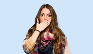 Uygunsuz bir şey izole mavi arka plan üzerinde söylediğin için el ile ağız kapsayan genç hippi kadın