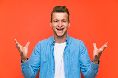 İzole duvar üzerinde sarışın yakışıklı adam mutsuz ve bir şey ile sinirli