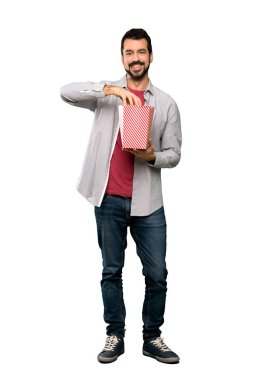 Popcorns izole beyaz arka plan üzerinde yemek sakallı yakışıklı adam tam uzunlukta atış