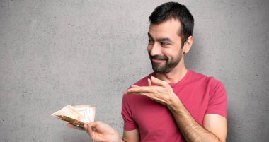 Adam dokulu duvara gelmek için davet için yan elleri uzanan çok para alarak