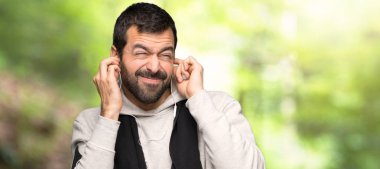 Spor adam el ile kulakları kaplayan. Bir parkta sinirli ifade