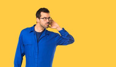 Ressam adam izole sarı arka planda kulak el koyarak bir şey dinlerken