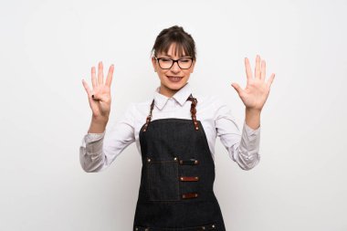 Önlüklü genç kadın parmaklarıyla dokuzu sayıyor.