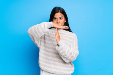 Süveteri olan genç Kolombiyalı bir kız bir hareketi durdurmak için eliyle jest yapıyor.