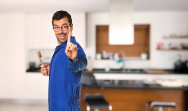 Ressam adam gösteren ve evde bir parmak kaldırma