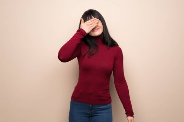 Kırmızı balıkçı yakalı genç bir kadın elleriyle gözlerini kapatıyor. Bir şey görmek istemiyorum.