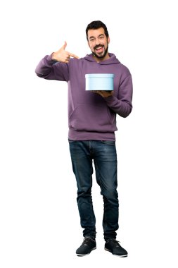 Yakışıklı bir hediye izole beyaz arka plan üzerinde tutarak kazak ile tam uzunlukta atış