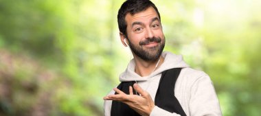 Spor adam bir parkta gelmek için davet için yan eller uzanan