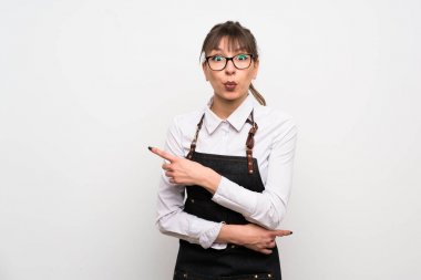 Önlüklü genç kadın şaşırmış ve işaret ediyor.