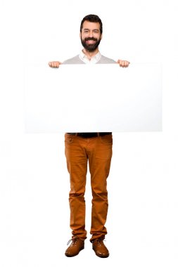 Boş bir afiş tutarak sakallı mutlu yakışıklı adam